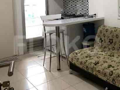 Compact kitchen with breakfast bar and sofa in a studio apartment.