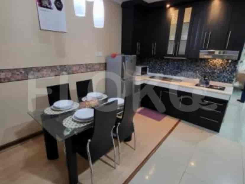 A modern kitchen with dark cabinetry and a dining area.