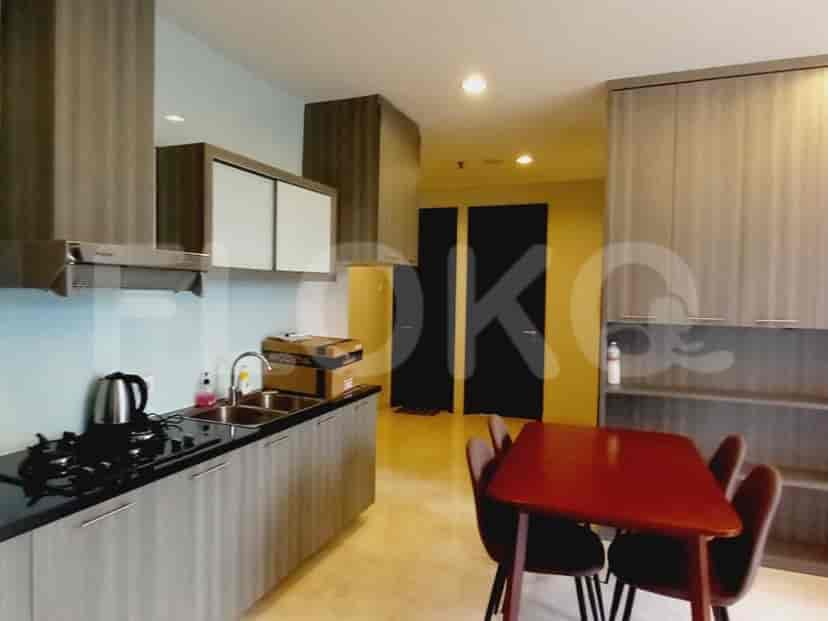 A modern kitchen with grey cabinets, a black stovetop, and a dining area.