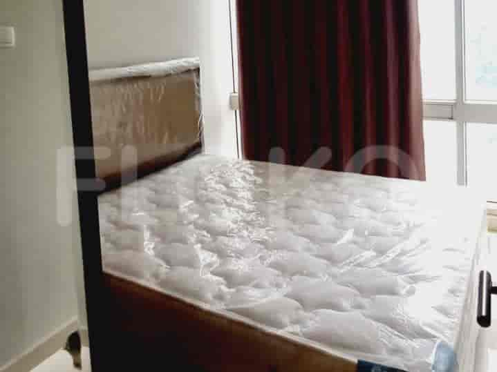 A detailed view of the bed with a headboard and a window.