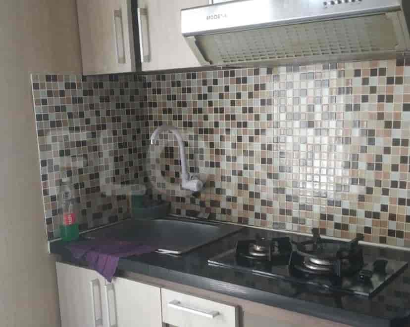 Compact kitchen with tiled backsplash, stainless steel sink, and gas stove.
