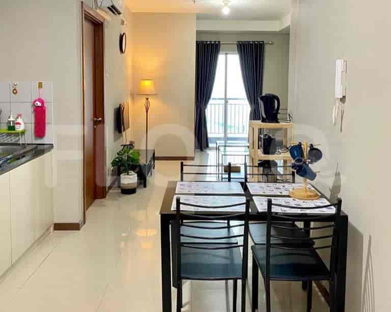 A dining area with a black dining table and chairs next to the kitchen.