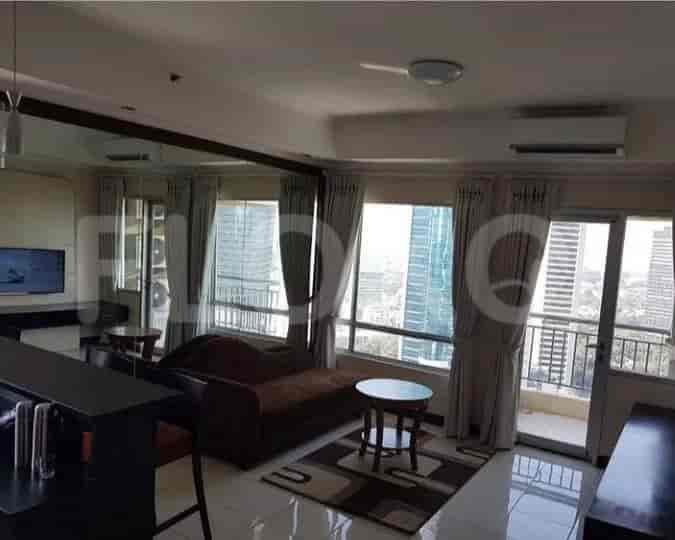 Spacious living room with brown sofa, glass table and a balcony.