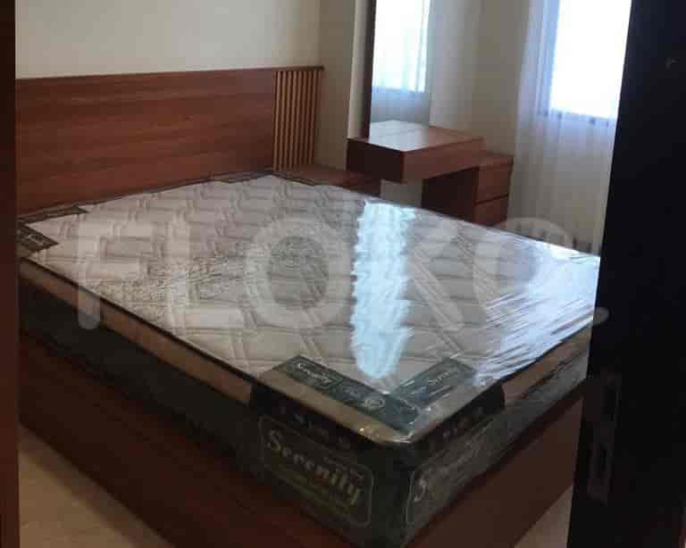 Another bedroom with a large bed, wooden headboard, and a dressing table.