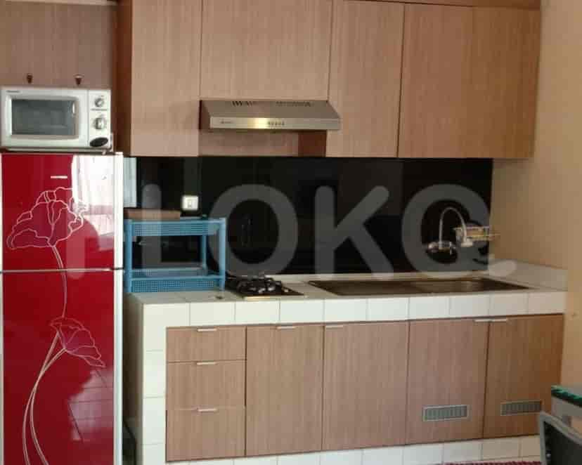 Small modern kitchen with a refrigerator and cabinetry.