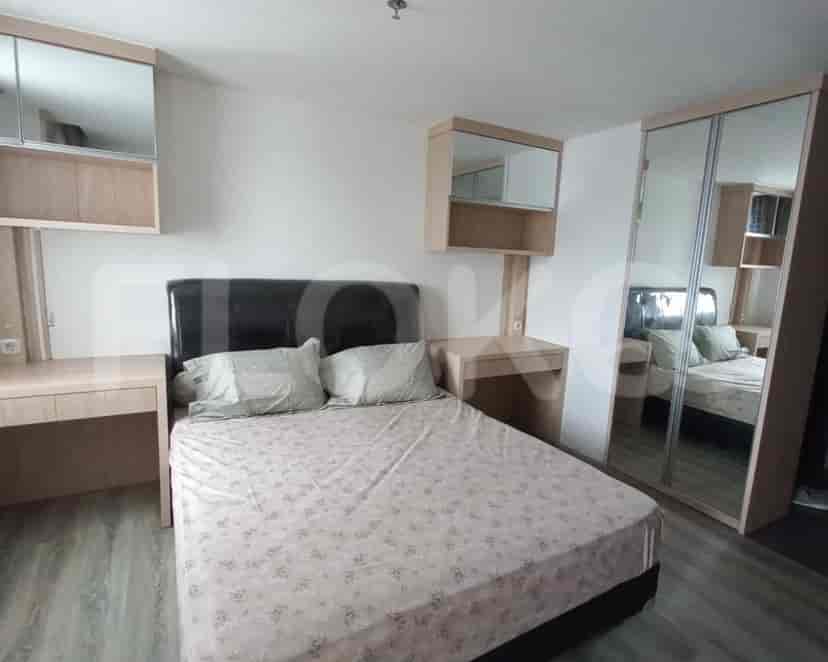 A modern bedroom with a double bed, built-in desk, and large mirror closet.