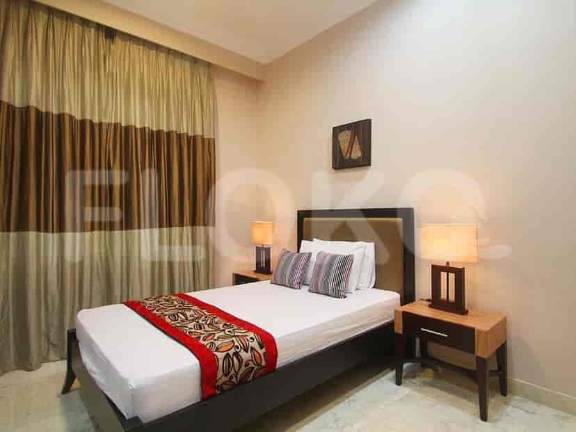 Kamar tidur dengan tempat tidur, meja samping, dan lampu.