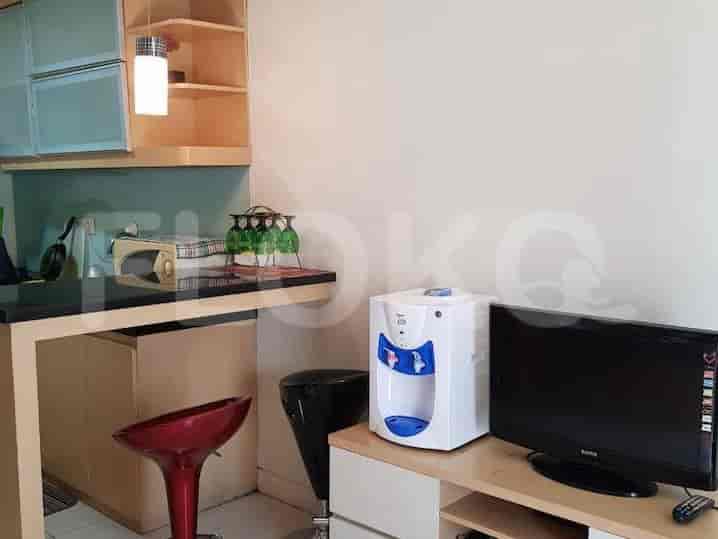 Kitchenette with a microwave, water dispenser, and small table.