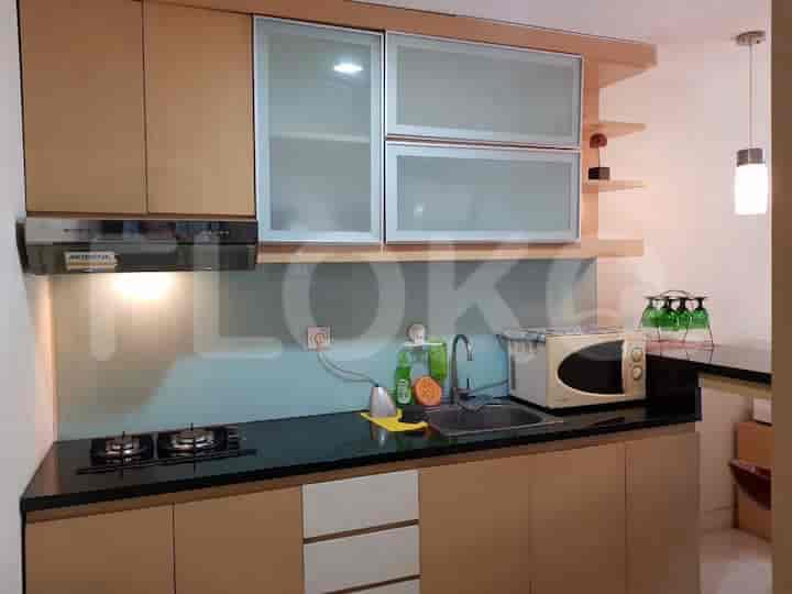 A kitchen with a stovetop, microwave, and cabinets.