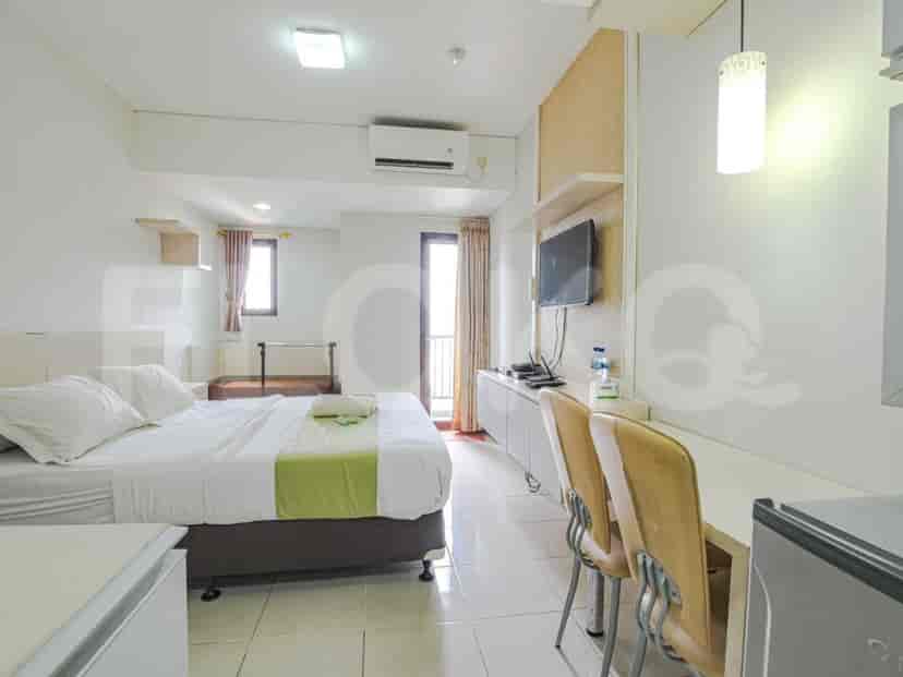 Bedroom with a double bed, TV, and balcony access.