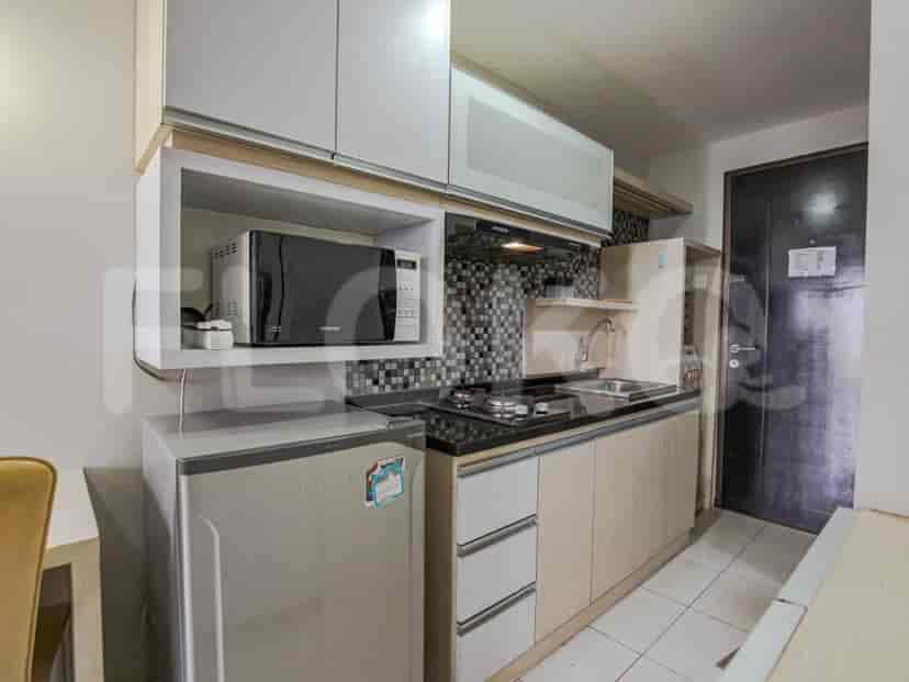 Compact kitchenette with a microwave, fridge, and stovetop.