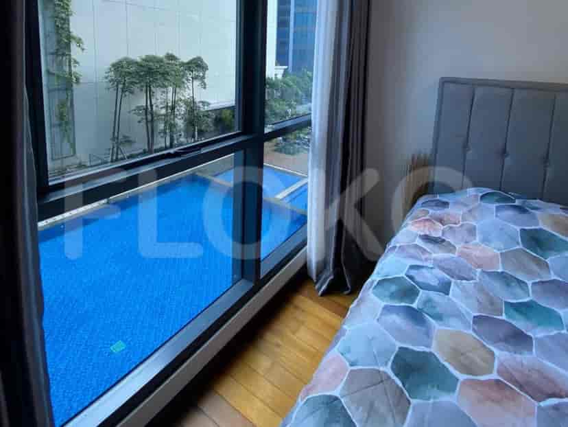 Bedroom with a bed, window, and view of a swimming pool.