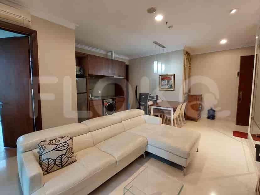 Another angle of the living room and kitchen, showcasing the sofa, dining area, and kitchen appliances.