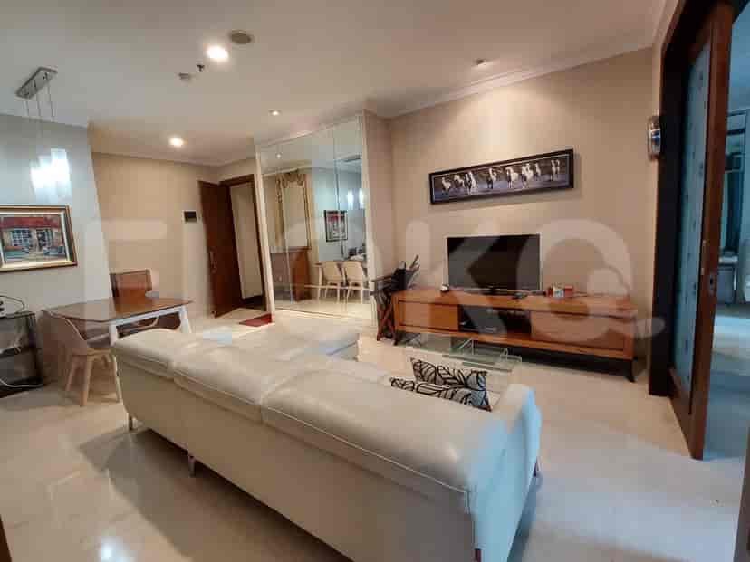 Spacious living room with a sofa, TV console, and large mirror.