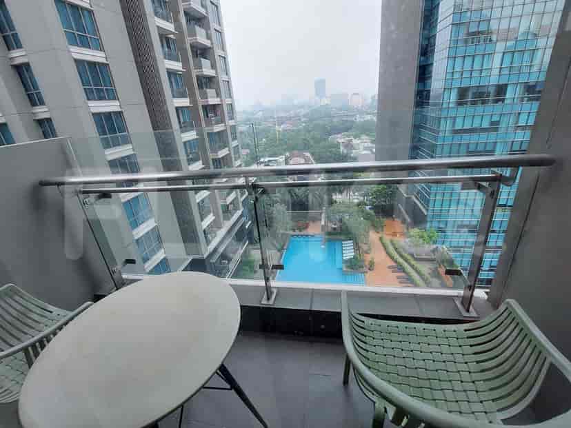 A balcony with a view of a swimming pool and surrounding buildings.