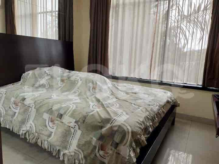 Bedroom with a large bed, window, and curtains.
