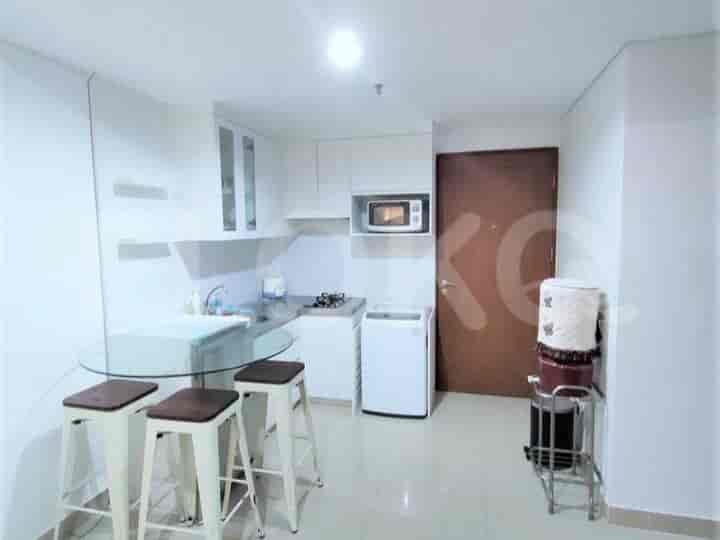 A kitchen with white cabinets, a gas stove, and a dining table with stools.