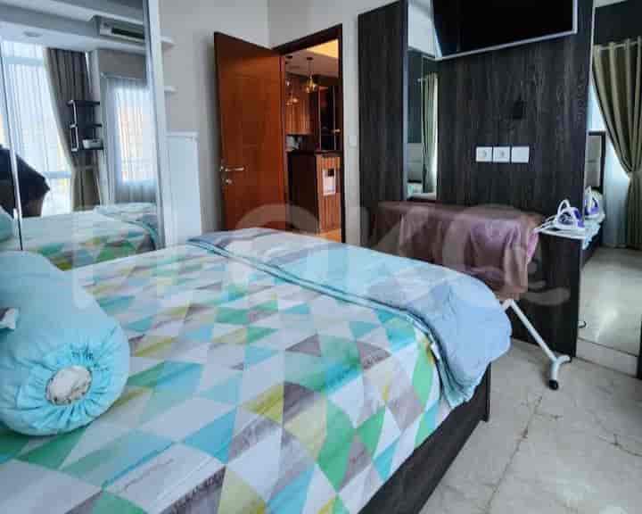A bedroom with a bed, mirror, and an ironing board.