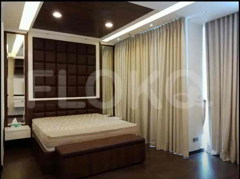 A bedroom featuring a bed, curtains, and bedside table.