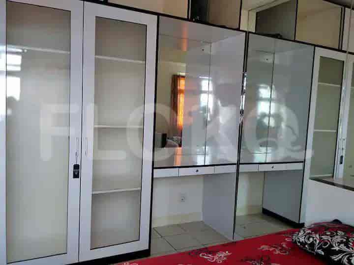 A bedroom with a large wardrobe and a bed visible in the mirror.