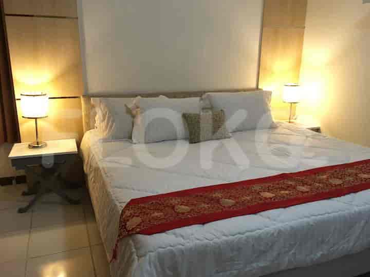 A well-lit bedroom with a large bed, bedside lamps, and elegant decor.