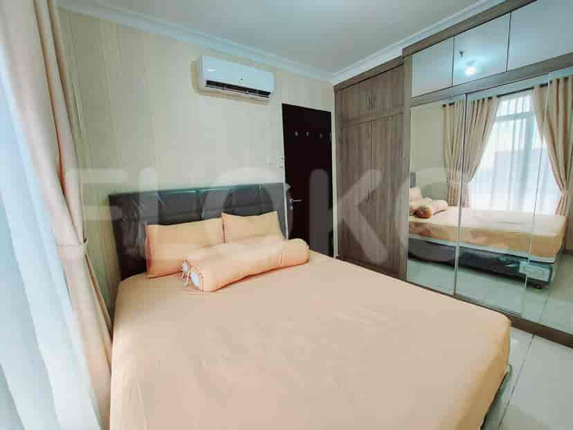 A well-lit bedroom with a bed, air conditioning, and a closet.