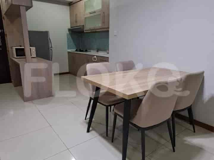 Dining area with a wooden table and chairs, adjacent to a small kitchen.