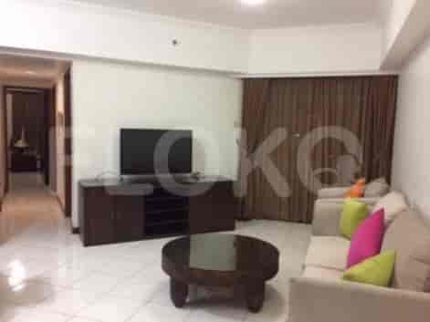 Living room with a TV, sofa, and round coffee table.