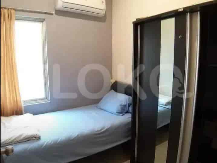 A bedroom with a single bed and a mirrored closet.