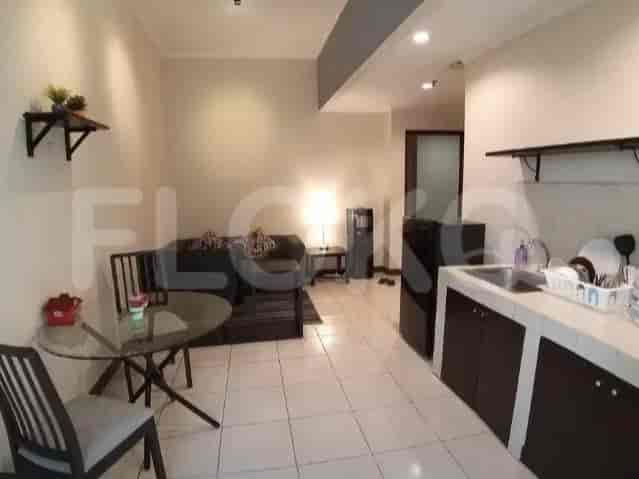 Living room and kitchen with a sofa, table and chairs, and a kitchen.
