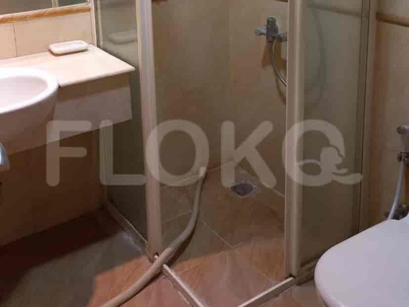 Kamar mandi dengan shower dan wastafel.