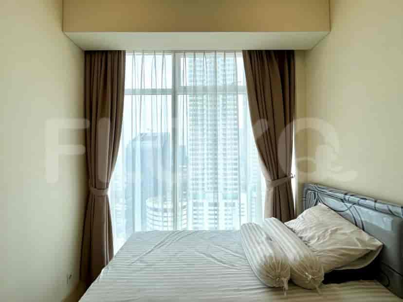 Bedroom with a queen bed, large windows, and curtains.