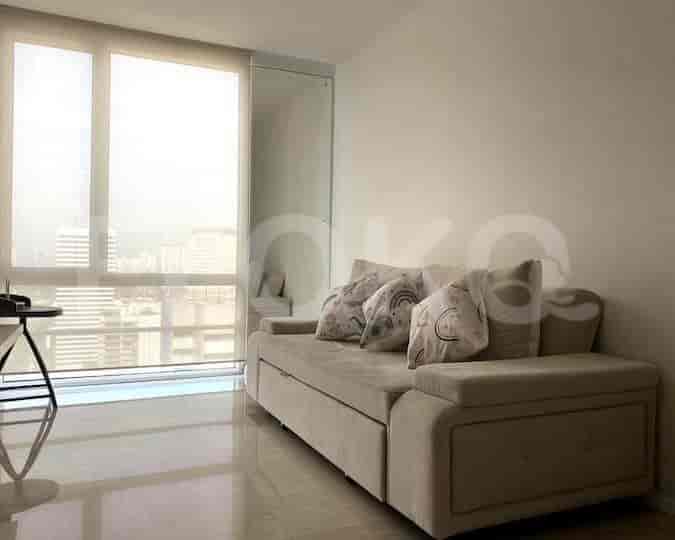 Living room with a beige sofa, large windows, and city views.