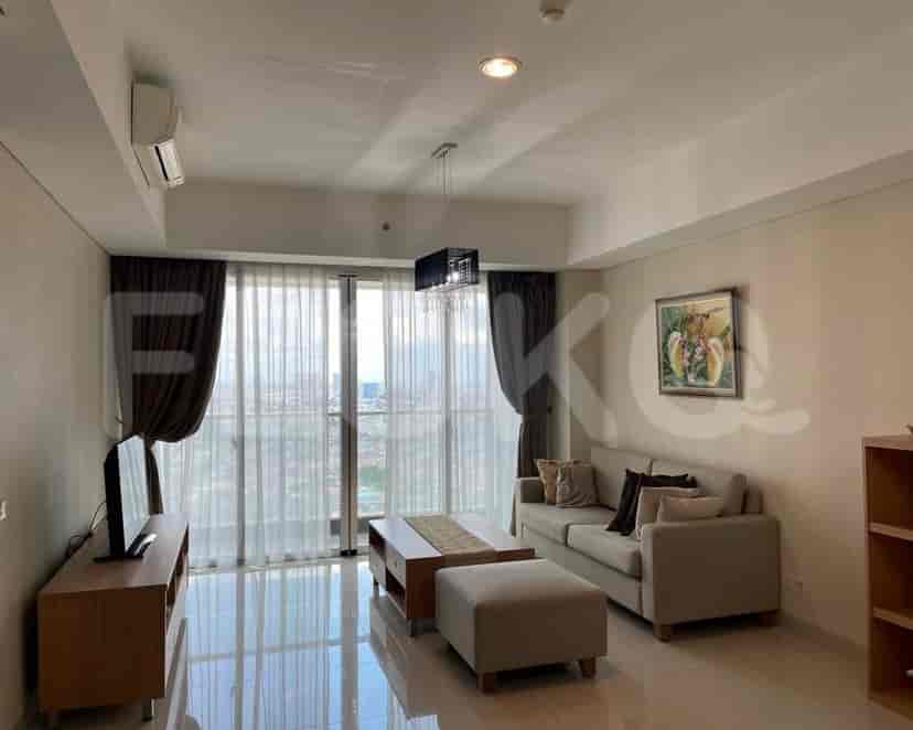 A modern living room with a grey sofa, entertainment unit, and large windows with curtains.