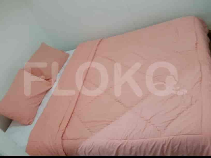 A bedroom featuring a bed with pink bedding.