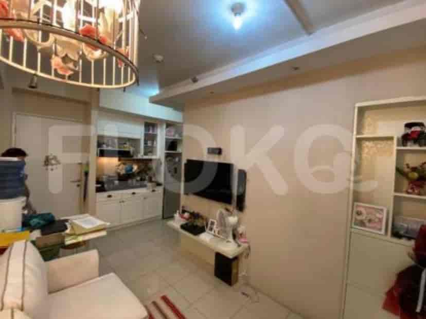 Living area showing a sofa, TV and some decorative lighting.