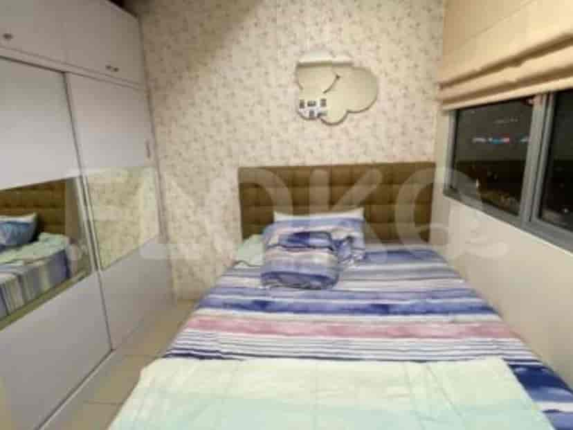 A neatly arranged bedroom with a bed, wardrobe and a decorative cloud mirror.