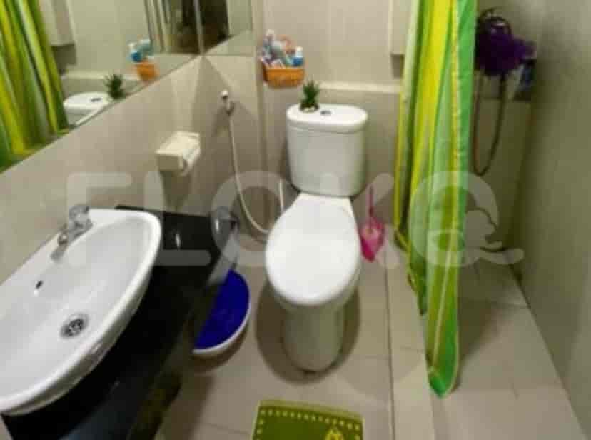 A bathroom equipped with a toilet, sink and a shower curtain.