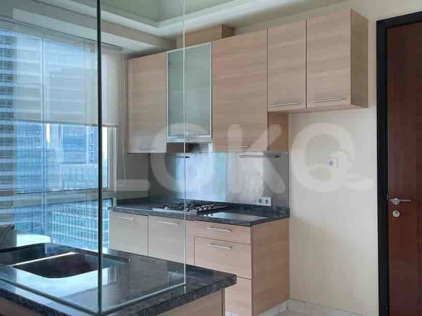 A modern kitchen with wood cabinets, stainless steel appliances, and a breakfast bar.