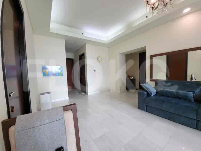 A spacious living room with marble flooring and a blue sofa.
