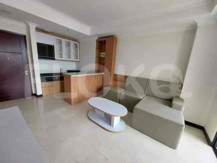 Modern living space with a kitchenette, featuring a sofa, coffee table, and a small kitchen area.