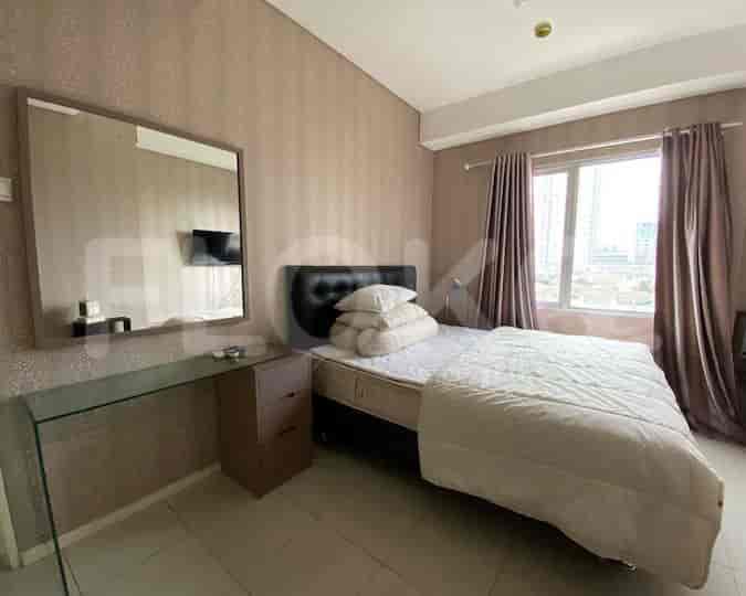 Kamar tidur dengan tempat tidur, cermin, dan jendela.