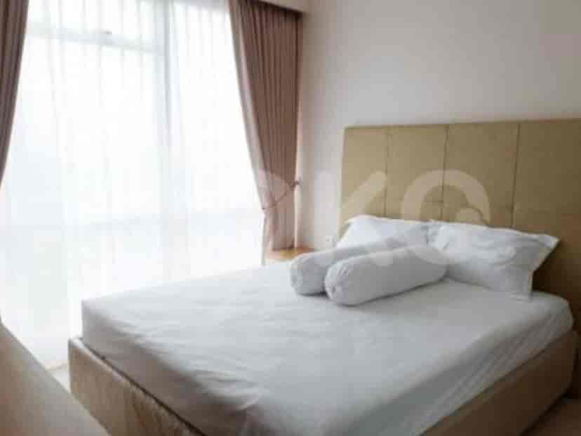 Kamar tidur yang cerah dengan tempat tidur besar dan gorden tipis.