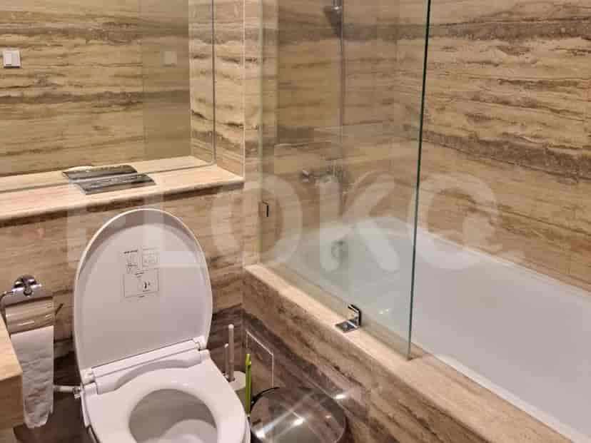 Bathroom with a bathtub and marble walls.