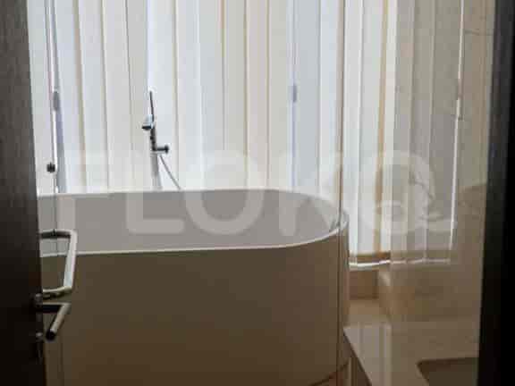 A modern bathroom with a bathtub and large window.
