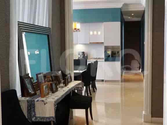 A hallway with a console table and access to a dining room.