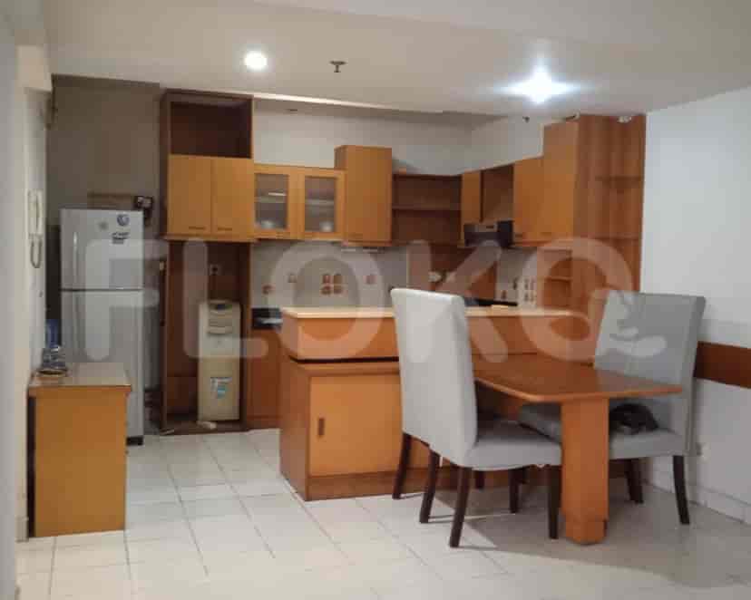 A kitchen with wooden cabinets, a dining table, and a refrigerator.
