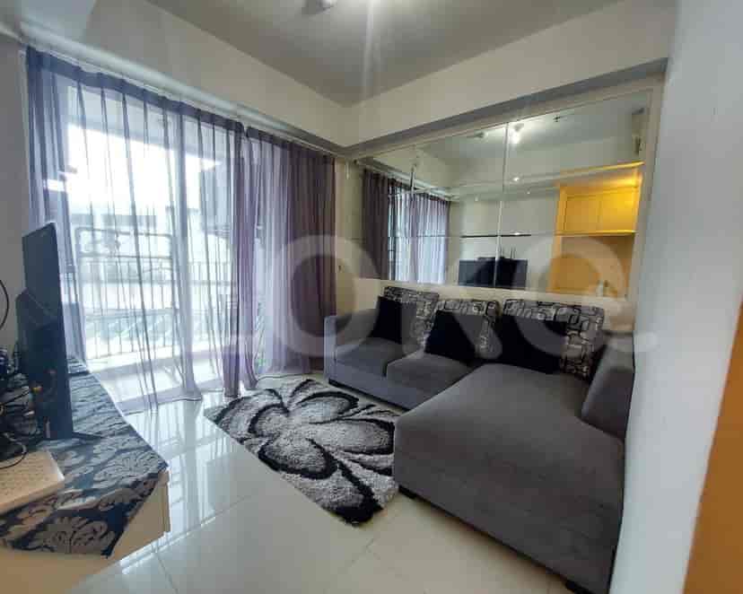 Modern living room with grey sofa, TV, and a large window with curtains.