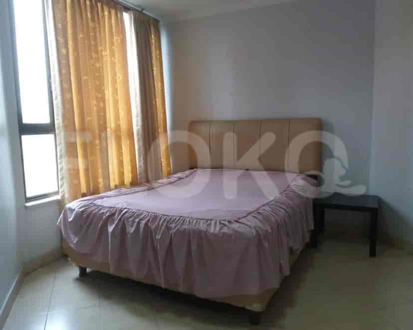 A bedroom with a bed, nightstand, and curtains.