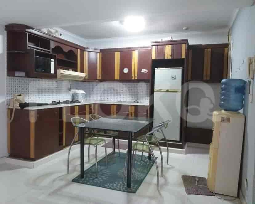 A kitchen featuring wooden cabinets, appliances, and a dining table.
